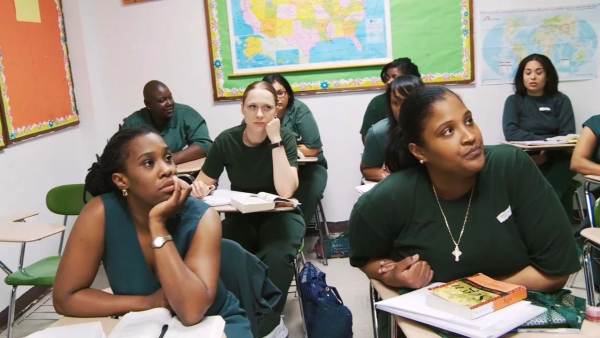 Participants in the Bard Prison Initiative sit at desks in a classroom.